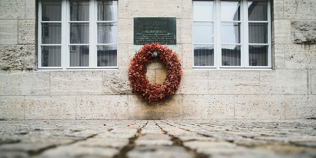 On this Friday, July 12, 2019 photo, a wreath fixed under a remembrance plaque marking the place where several leaders of the failed assassination to Adolf Hitler on July 20, 1944 were shot dead, in the courtyard of the Bendlerblock building of the German defensive ministry, in Berlin. Germany is marking the 75th anniversary of the most famous plot to kill Adolf Hitler. (AP Photo/Markus Schreiber)