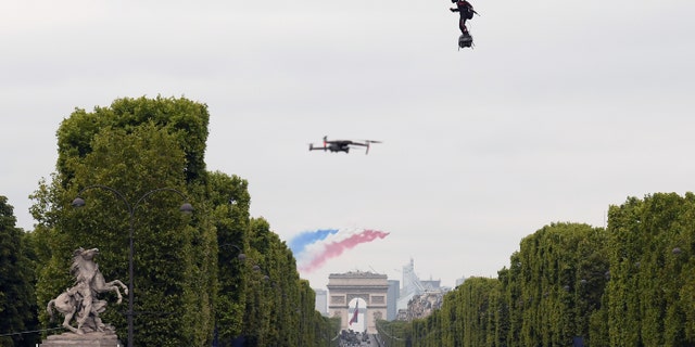 Zapata CEO Franky Zapata flies a jet-powered hoverboard or "Flyboard" as French elite acrobatic flying team "Patrouille de France" flies over the Arc de Triomphe during the Bastille Day military parade down the Champs-Elysees avenue in Paris on July 14, 2019. (Getty Images)