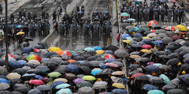 Protesters in Hong Kong pushed barriers and dumpsters into the streets early Monday morning in an apparent bid to block access to a symbolically important ceremony marking the anniversary of the return of the former British colony to China.