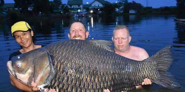 John Harvey, no centro, diz que pegou um peixe carpa de 232 libras na TailÃ¢ndia.