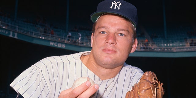 New York Yankee pawn, Jim Bouton, is wearing his glove and holding a baseball.