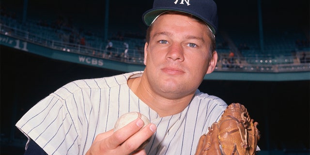 New York Yankee pawn, Jim Bouton, is wearing his glove and holding a baseball.