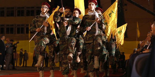 Fighters with the Lebanese Shiite Hezbollah party, carry flags as they parade in a southern suburb of the capital Beirut, to mark the al-Quds (Jerusalem) International Day, on May 31, 2019.