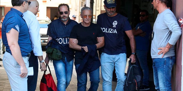 Suspect Rosario Gambino, center, is taken into custody during an anti-mafia operation lead by the Italian Police and the FBI in Palermo, Southern Italy, Wednesday, July 17, 2019. Italian police and the FBI arrested 19 suspected Mafiosi in a joint operation Wednesday following an investigation which revealed alleged ties between Sicily's Cosa Nostra Mafia and New York's Gambino crime family.