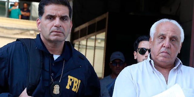 Suspect Tommaso Inzerillo, right, is taken into custody during an anti-mafia operation lead by the Italian Police and the FBI in Palermo, Southern Italy, Wednesday, July 17, 2019. Italian police and the FBI arrested 19 suspected Mafiosi in a joint operation Wednesday following an investigation which revealed alleged ties between Sicily's Cosa Nostra Mafia and New York's Gambino crime family.