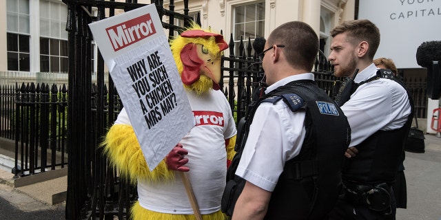 Police officers speak to a Daily Mirror campaigner dressed as a chicken outside a venue where then Chancellor of the Exchequer, Philip Hammond and Secretary of State for Exiting the European Union, David Davis, were due to speak