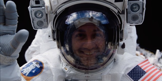 Astronaut Mike Massimino peers into space shuttle Columbia's crew cabin during a brief break in work on the Hubble Space Telescope on March 5, 2002.