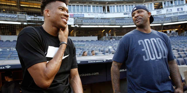 Milwaukee Bucks forward and 2019 NBA Most Valuable Player Giannis Antetokounmpo, left, talks to New York Yankees starting pitcher CC Sabathia before a baseball game between the Yankees and the Tampa Bay Rays, Monday, July 15, 2019, in New York. (AP Photo/Kathy Willens)