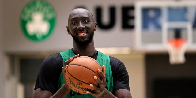 Boston Celtics rookie Tacko Fall, of Senegal, smiles as he shoots free throws after an NBA basketball practice at the team's training facility in Boston, Monday, July 1, 2019. Fall, who is about seven and a half feet tall, played previously for Central Florida. (AP Photo/Charles Krupa)