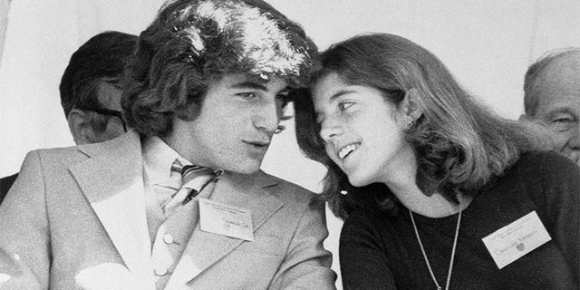 John F. Kennedy Jr. và chị gái của anh, Caroline, trò chuyện trong khi tham dự một buổi lễ mà người cha quá cố của họ được vinh danh.