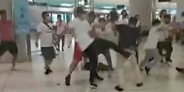 This Sunday, July 21, 2019, image taken from a video, shows confrontation between masked assailants and protesters at Yuen Long MTR train station in Hong Kong.