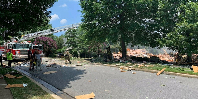 Firefighters looking over the wreckage following the fire and explosion at the home in Charlotte on Tuesday.