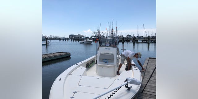 Sonny Schindler, owner and guide for Shore Thing Fishing Charters, ties his boat up to a dock. He said he's had to work harder to hold onto his customers after the emergence of the toxic algae blooms. (Fox News/ Charles Watson)