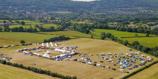 Drone pictures of the field near the Three Counties Showground show a red double-decker party bus and gazebo covering several double-beds.