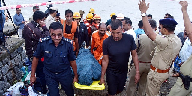 National Disaster Response Force (NDRF) personnel carry the body of missing Indian coffee tycoon V.G. Siddhartha from the banks of Netravati river towards an ambulance after local fishermen found it floating in the coastal city of Mangalore in the southern state of Karnataka on July 31, 2019. (STR/AFP/Getty Images)