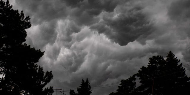 A storm bringing dark clouds, strong winds and a drop in temperature moves in over Flint, Mich., on Saturday, July 20, 2019.