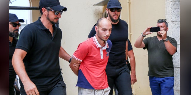 Plain-clothes police officers escort the suspect (C) for the murder of American biologist Suzanne Eaton to the prosecutor in Chania, on the island of Crete, Greece, Tuesday.