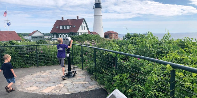 Children take in the view at Fort Williams Park at Cape Elizabeth, Maine, on Thursday, July 18, 2019, where a plaque, foreground, remembers those killed when the USS Eagle PE-56 was sunk During World War II off the Maine coast on April 23, 1945.