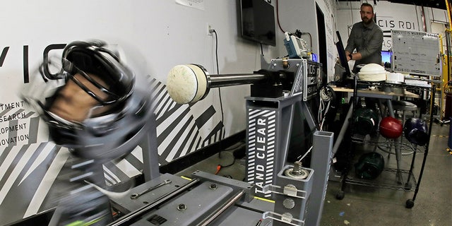 Ryan Smith, a test engineer at VICIS, runs an impact test on a helmet in Seattle. (AP)