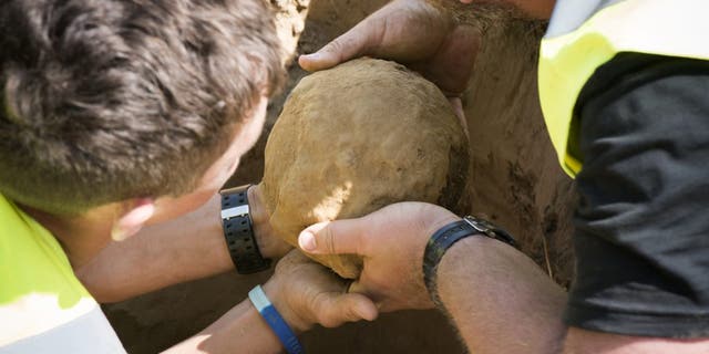 Oliver Horncastle and Alastair Eager removing the howitzer shell from the battlefield site.