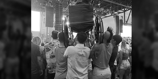 A woman using a wheelchair got a great view when a group of good Samaritans hoisted her up on their shoulders so she could see the stage. (Kate Marthaler)