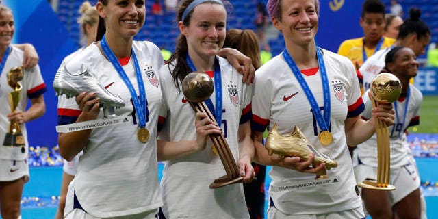 United States' Megan Rapinoe, right, United States' Alex Morgan, left, and United States' Rose Lavelle, center, pose with their trophies after the Women's World Cup final soccer match between US and The Netherlands. (AP Photo/Alessandra Tarantino)