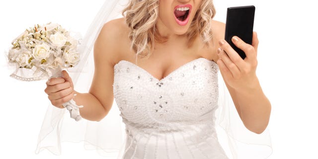 Furious bride looking at her phone