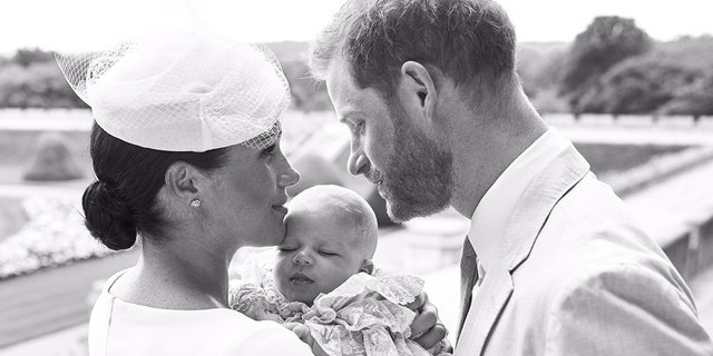 An official christening photo released by the Duke and Duchess of Sussex on Saturday, July 6, 2019, showing Britain's Prince Harry, right and Meghan, the Duchess of Sussex with their son Archie Harrison Mountbatten-Windsor at Windsor Castle with with the Rose Garden in the background, in Windsor, England. (Chris Allerton/SussexRoyal via AP)