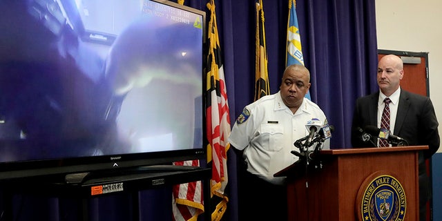 Baltimore Police Commissioner Michael Harrison, center, and Capt. Donald Diehl look on as the department makes public portions of footage from the body camera worn by Sgt. Billy Shiflett, who was shot while responding to an active shooter call at Baltimore addiction clinic at a news conference, on July 23.