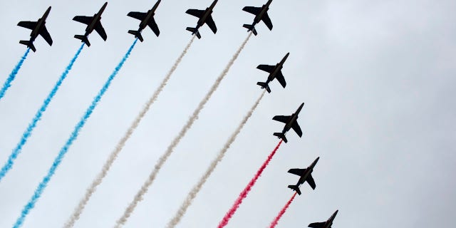 French Alpha jets of the Patrouille de France spray lines of smoke in the colors of the French flag over the Champs-Elysees during Bastille Day parade Sunday, July 14, 2019, near the Champs Elysees avenue in Paris.