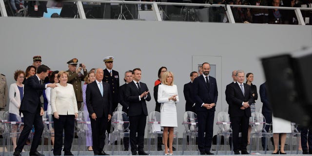 From the left, Dutch Prime Minister Mark Rutte, German Chancellor Angela Merkel, Portugal's President Marcelo Rebelo de Sousa, French President Emmanuel Macron, his wife Brigitte, French Prime Minister Edouard Philippe and Finnish President Sauli Niinisto attend Bastille Day parade Sunday, July 14, 2019, on the Champs Elysees avenue in Paris