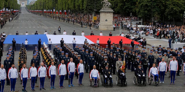 Veterans walk on the Champs-Elysees avenue during the Bastille Day parade in Paris, France, Sunday, July 14, 2019.