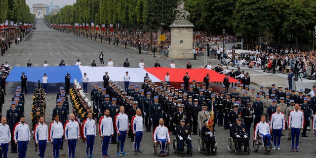 Veterans walk on the Champs-Elysees avenue during the Bastille Day parade in Paris, France, Sunday, July 14, 2019.