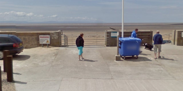 A sign at the entrance to the beach warns drivers about the tides.