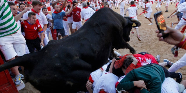 A cow jumps over revelers following the running of the bulls at the San Fermin Festival, in Pamplona, northern Spain, Wednesday, July 10, 2019. (AP Photo/Alvaro Barrientos)