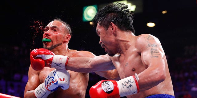 Manny Pacquiao, right, lands a punch against Keith Thurman in the fifth round during a welterweight title fight Saturday, July 20, 2019, in Las Vegas. (AP Photo/John Locher)