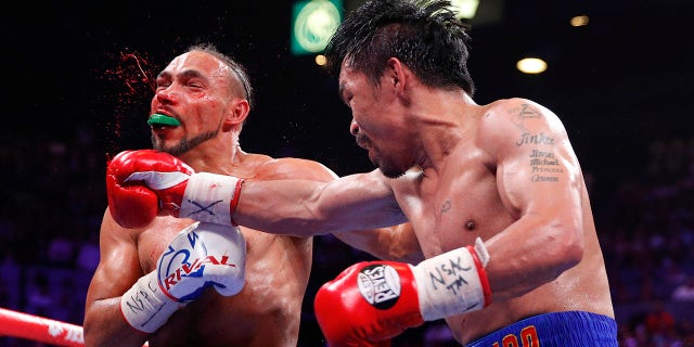 Manny Pacquiao, right, lands a punch against Keith Thurman in the fifth round during a welterweight title fight Saturday, July 20, 2019, in Las Vegas. (AP Photo/John Locher)