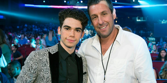 Cameron Boyce poses with Adam Sandler at the 2017 Radio Disney Music Awards. Sandler, who starred as Boyce's father in "Grown Ups" and "Grown Ups 2," honored the late star with donations to The Thirst Project.