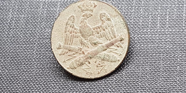 An artillery button of Napoleon's Grand Armee that was discovered in Lithuania. (Jon Seligman, Israel Antiquities Authority)