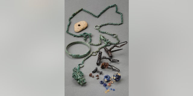 Restored found objects, including a belt chain, bracelet, brooches, glass and amber beads. (Credit: Martin Bachmann, Kantonsarchäologie Zürich)