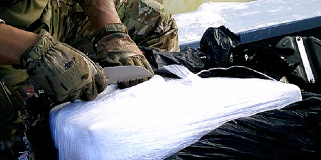 A Coast Guard Cutter Robert Ward crew member inspects and prepares to test suspected contraband seized from a suspected drug smuggling boat in international waters of the Eastern Pacific Ocean, July 16, 2019. 