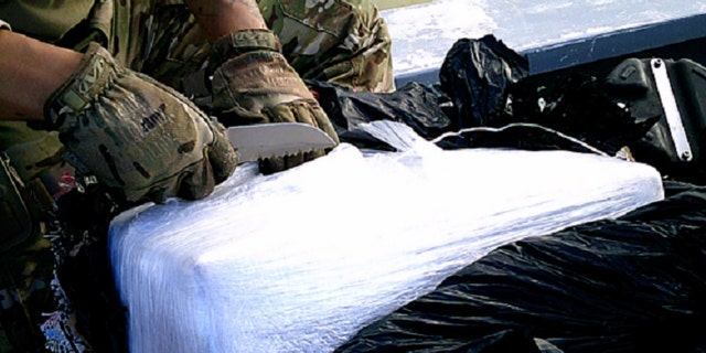 A Coast Guard Cutter Robert Ward crew member inspects and prepares to test suspected contraband seized from a suspected drug smuggling boat in international waters of the Eastern Pacific Ocean, July 16, 2019.