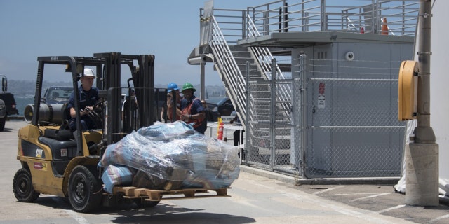 A crewmember of Coast Guard Cutter Steadfast uses a forklift to move a pallet of cocaine in San Diego, July 26, 2019.