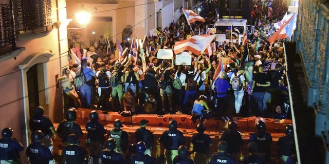 Demonstrators protest against governor Ricardo Rossello, in San Juan, Puerto Rico, Friday, July 19, 2019. Protesters are demanding Rossello step down for his involvement in a private chat in which he used profanities to describe an ex-New York City councilwoman and a federal control board overseeing the island's finance.