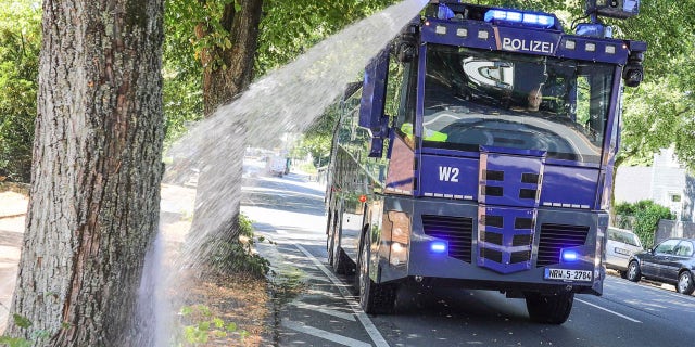 A water cannon of the German police waters trees in Wuppertal, western Germany, Wednesday, July 24, 2019. Hot temperatures are expected all over Europe during the next days.