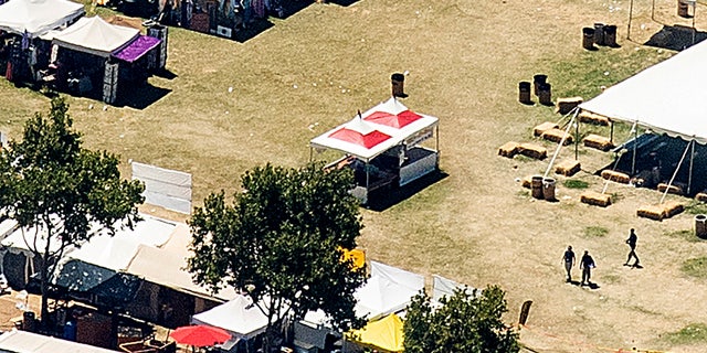 In this aerial photo, emergency personnel, right, walk among vendor booths at Christmas Hill Park on Monday in Gilroy, Calif., the site of a shooting the day before at the Gilroy Garlic Festival.