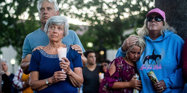 Susan Meyers and husband Michael Oshan listen to a hymn during a vigil Monday for victims of the shooting. (AP)