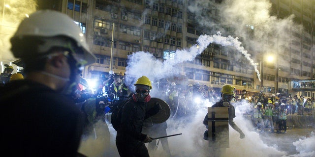 Protesters react to tear gas during a confrontation with riot police in Hong Kong Sunday, July 21, 2019.