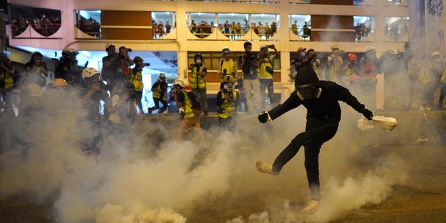 A protestor kicks a tear gas canister during confrontation in Hong Kong Sunday, July 21, 2019.