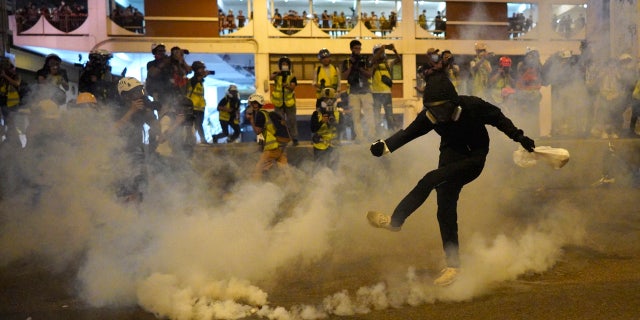 A protestor kicks a tear gas canister during confrontation in Hong Kong Sunday, July 21, 2019.